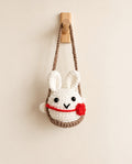 Handmade crochet bunny hanging on white background
